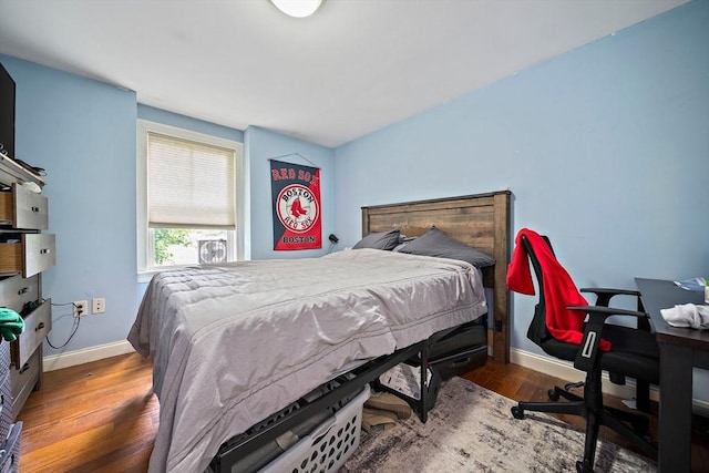bedroom with baseboards and wood finished floors