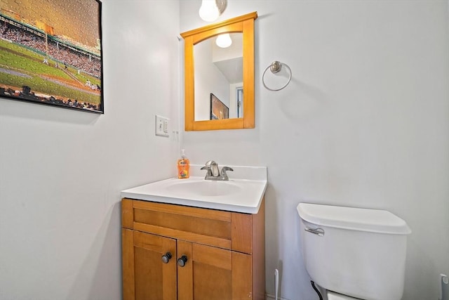 half bathroom featuring vanity and toilet