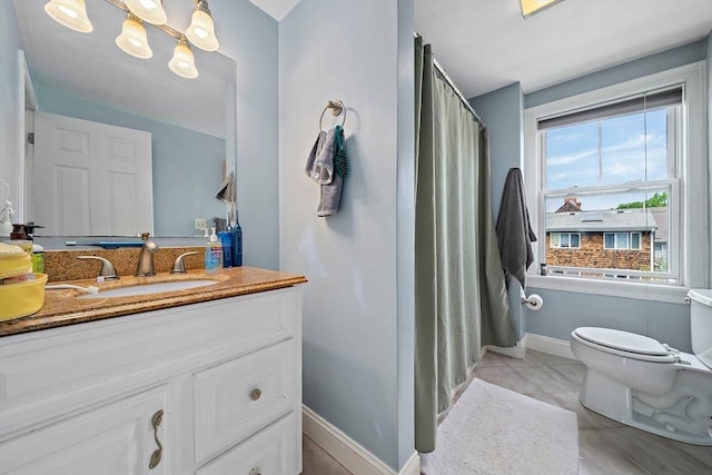 bathroom featuring toilet, vanity, tile patterned floors, baseboards, and curtained shower