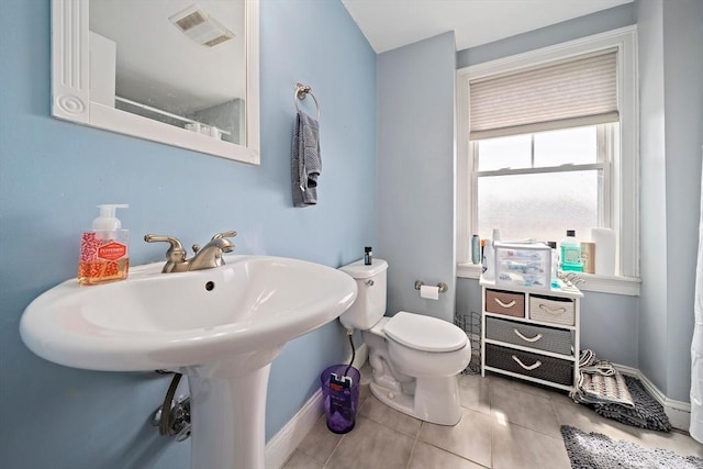 bathroom with tile patterned flooring, toilet, and baseboards