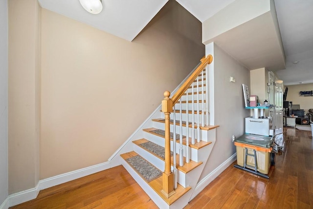 stairway featuring hardwood / wood-style floors and baseboards