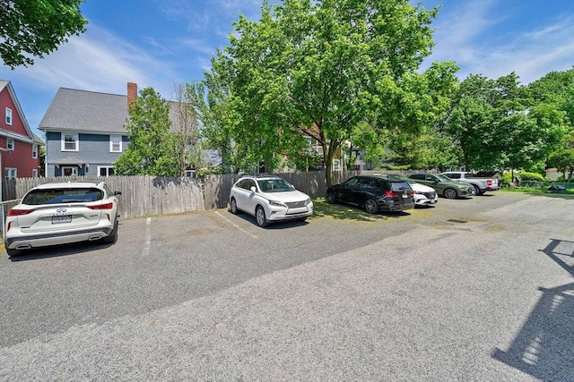 uncovered parking lot featuring fence