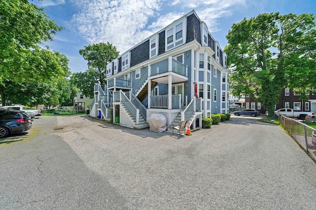 view of building exterior featuring stairway and fence