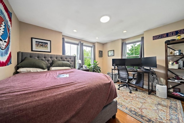 bedroom with multiple windows, wood finished floors, recessed lighting, and a desk
