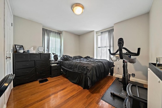 bedroom featuring wood finished floors and multiple windows