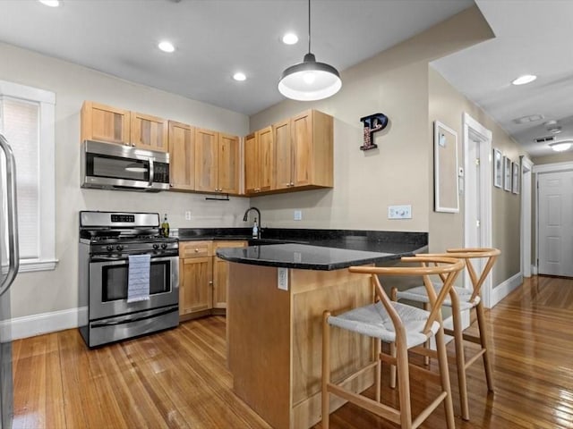 29 Chelmsford St Unit 2, Boston, MA 02122 - kitchen with appliances with stainless steel finishes, wood finished floors, a peninsula, a kitchen bar, and recessed lighting