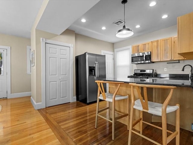 29 Chelmsford St Unit 2, Boston, MA 02122 - kitchen with appliances with stainless steel finishes, a peninsula, dark countertops, light wood finished floors, and recessed lighting