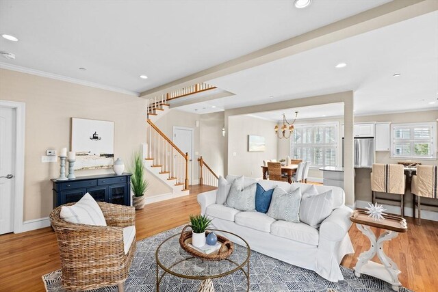 living room with crown molding, stairway, and light wood finished floors