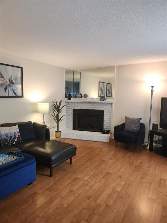 37 Mountain Gate Rd Unit 37, Ashland, MA 01721 - living area with wood finished floors, a fireplace, and a textured ceiling