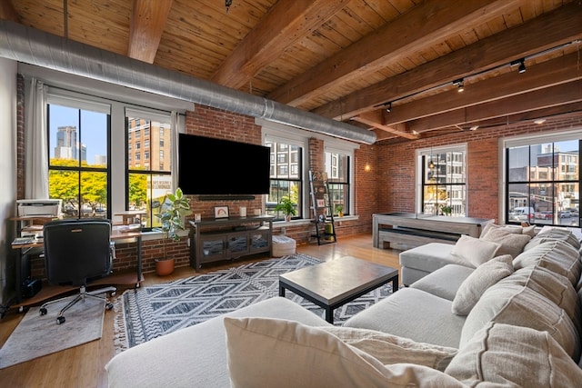 living room with beam ceiling, rail lighting, hardwood / wood-style flooring, wooden ceiling, and brick wall