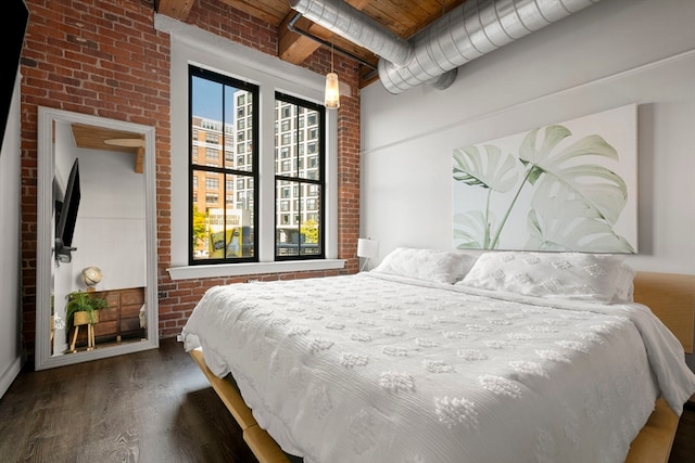 bedroom with dark hardwood / wood-style floors, wooden ceiling, and brick wall