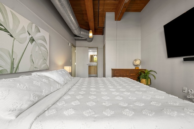 bedroom featuring beam ceiling, connected bathroom, and wooden ceiling