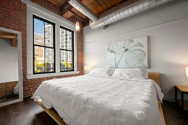 bedroom featuring brick wall, dark wood-type flooring, and wooden ceiling