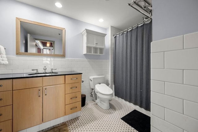 bathroom featuring toilet, vanity, tile walls, and tile patterned flooring