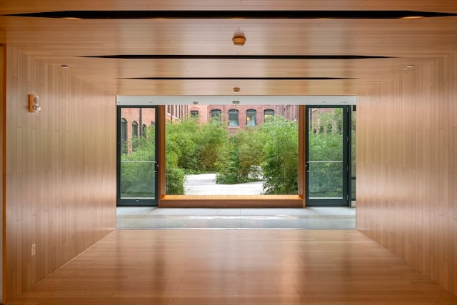 entryway featuring wooden ceiling, light hardwood / wood-style flooring, and wooden walls