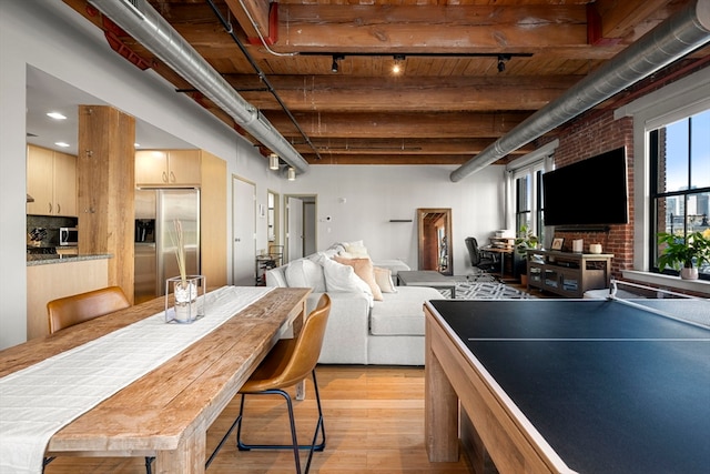 recreation room with light hardwood / wood-style floors and beam ceiling