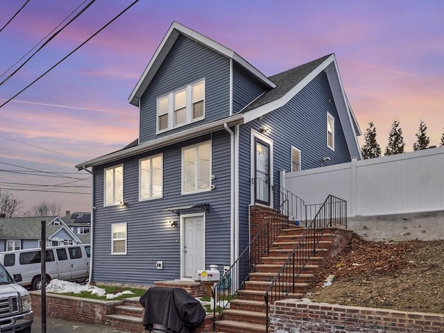 view of front of property with fence and stairway