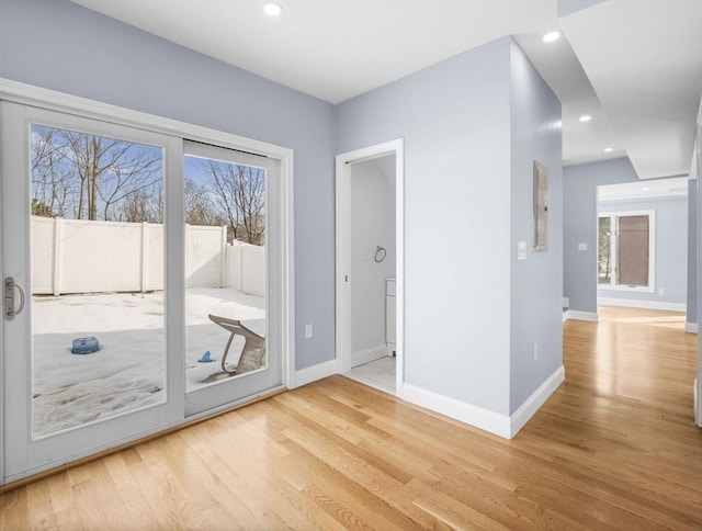 doorway to outside featuring light wood-style flooring, baseboards, a wealth of natural light, and recessed lighting