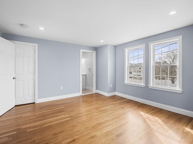 unfurnished bedroom featuring light wood finished floors, baseboards, and recessed lighting