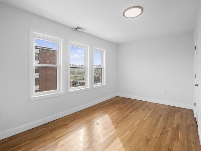 empty room with light wood-style floors and baseboards