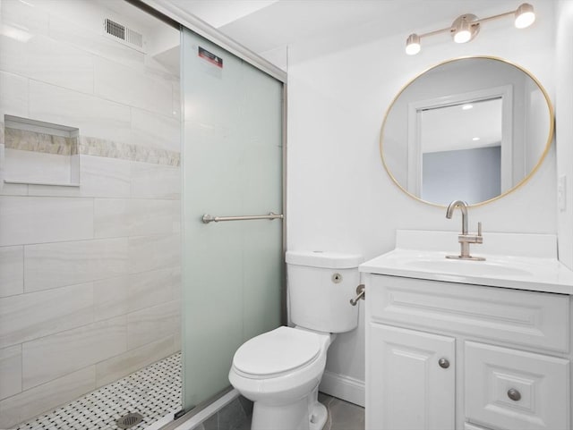 bathroom with visible vents, vanity, a tile shower, and toilet