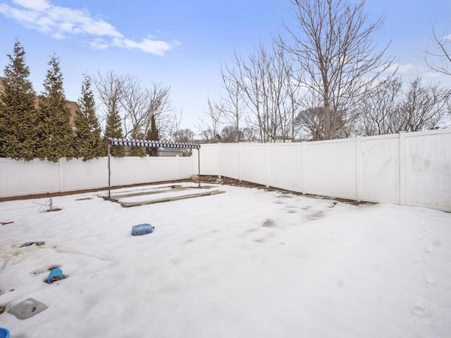 snowy yard featuring a fenced backyard