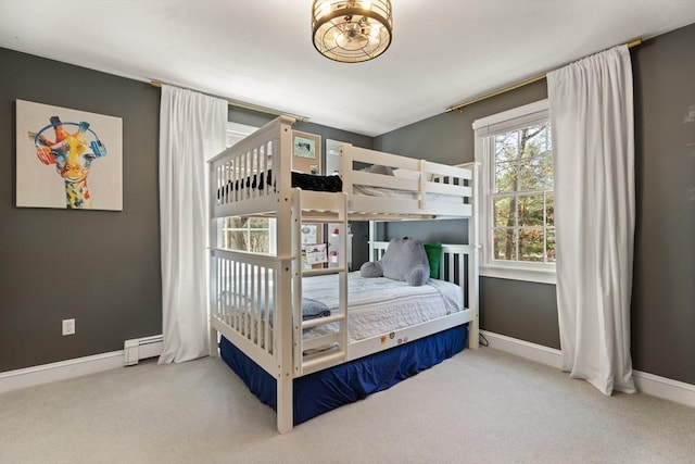 carpeted bedroom with baseboards, a baseboard radiator, and a notable chandelier