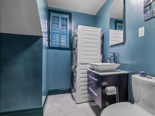 10 John A Andrew St, Boston, MA 02130 - bathroom featuring stacked washing machine and dryer, toilet, vanity, and marble look tile flooring