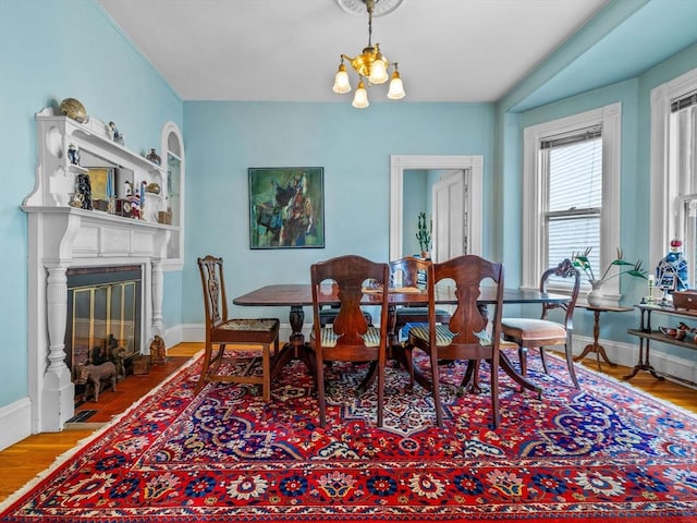 10 John A Andrew St, Boston, MA 02130 - dining space with baseboards, wood finished floors, a chandelier, and a fireplace with flush hearth