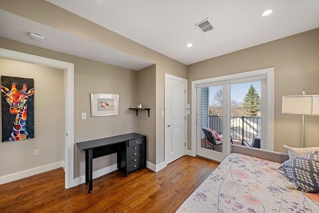 bedroom featuring visible vents, wood finished floors, baseboards, and access to exterior