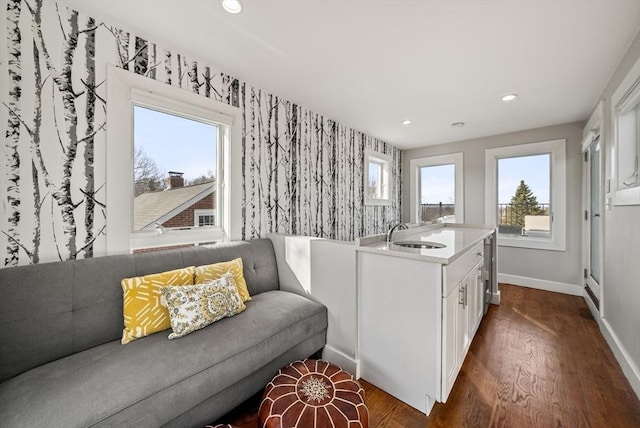 interior space featuring wallpapered walls, dark wood finished floors, recessed lighting, white cabinetry, and a sink