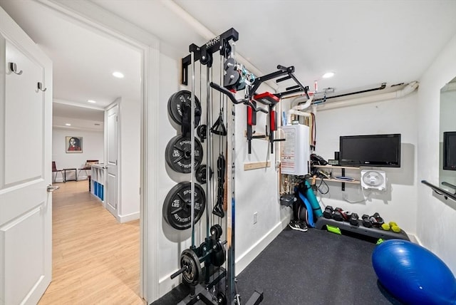 workout room with recessed lighting, baseboards, and wood finished floors