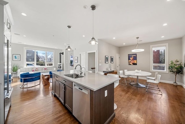 kitchen with dishwasher, dark wood-style floors, open floor plan, and a sink