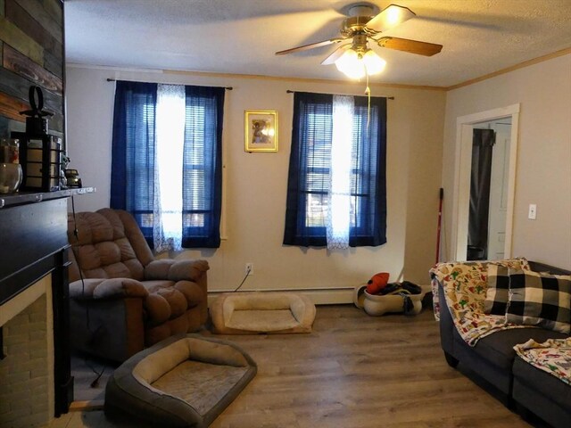 living room with ceiling fan, hardwood / wood-style floors, a healthy amount of sunlight, and a textured ceiling