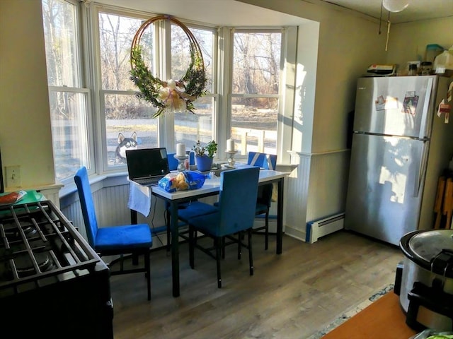 dining space with hardwood / wood-style floors and a baseboard radiator