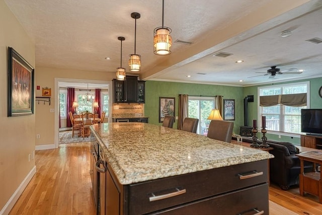 59 Davis St, Northborough, MA 01532 - kitchen with light wood-style flooring, healthy amount of natural light, light stone countertops, recessed lighting, and a textured ceiling