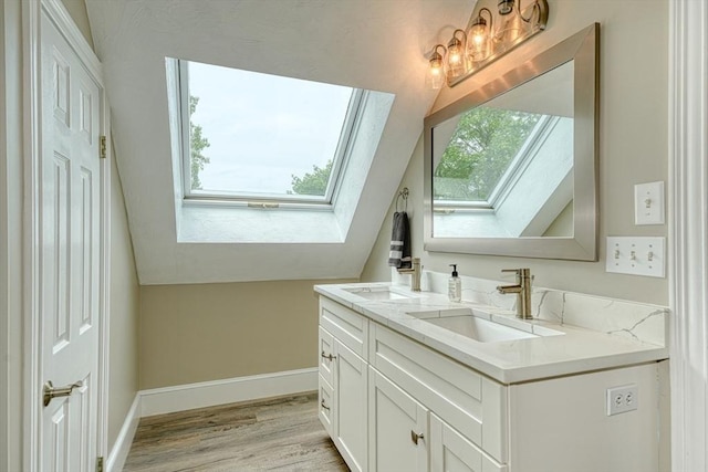 59 Davis St, Northborough, MA 01532 - bathroom with a skylight, double vanity, lofted ceiling, and wood finished floors