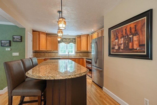 59 Davis St, Northborough, MA 01532 - kitchen with freestanding refrigerator, range, light wood-style floors, decorative backsplash, and light stone countertops
