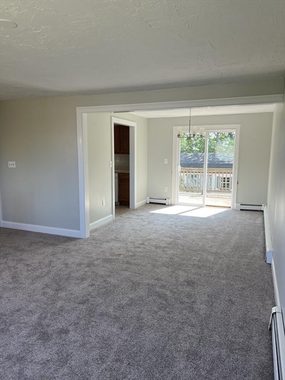 11 Skyview Ln, Woburn, MA 01801 - spare room featuring light carpet, a textured ceiling, and a baseboard heating unit
