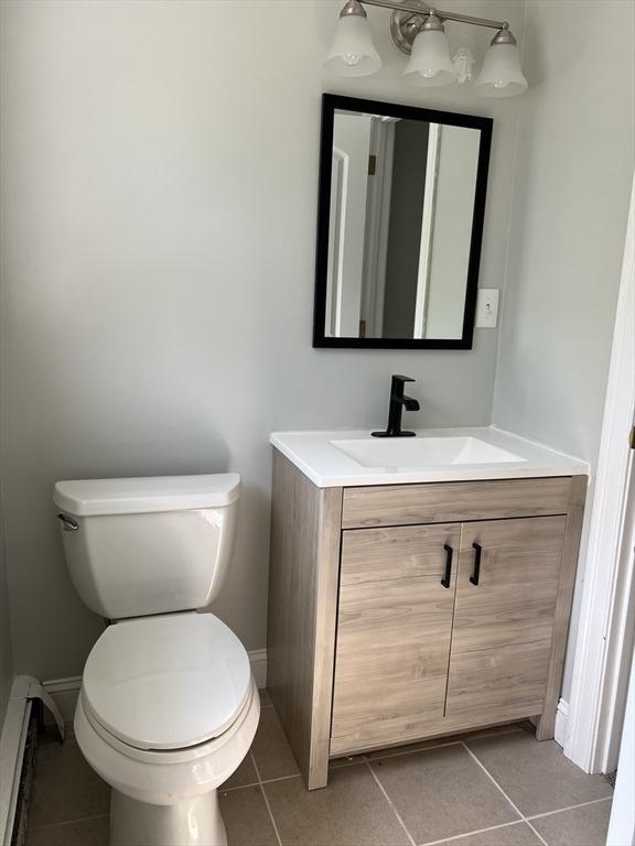 11 Skyview Ln, Woburn, MA 01801 - half bath featuring vanity, tile patterned flooring, and a baseboard radiator