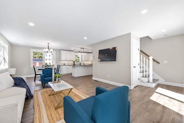 living room featuring light wood-type flooring and a chandelier