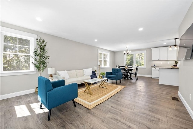 living room featuring a notable chandelier and light wood-type flooring