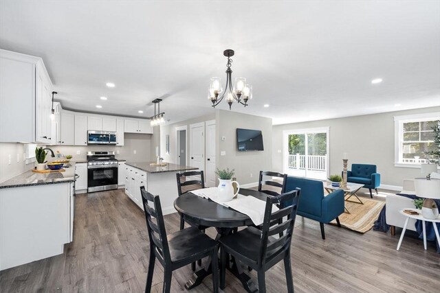 dining area with an inviting chandelier, hardwood / wood-style floors, and sink