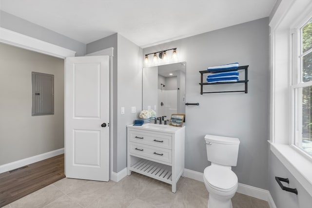 bathroom with tile patterned floors, toilet, electric panel, and vanity