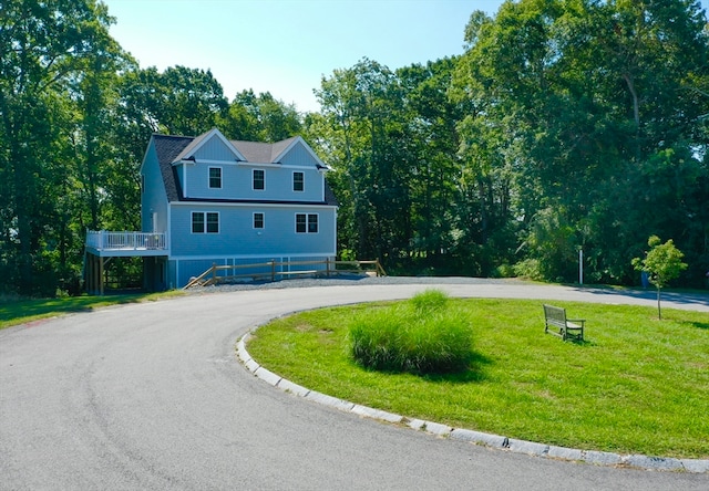 view of front facade featuring a front yard and a wooden deck