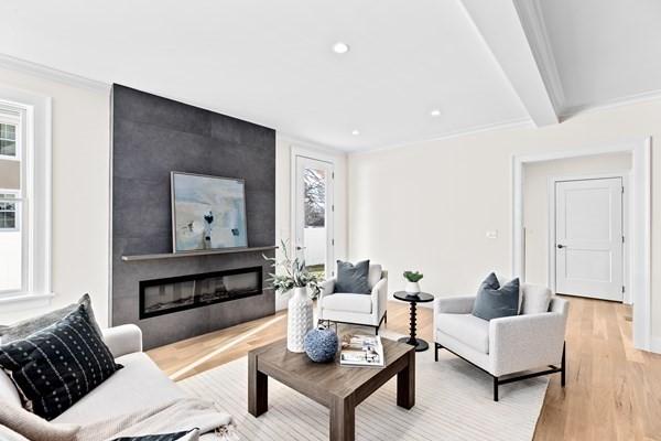 32 Kingsbury St Unit 1, Wellesley, MA 02481 - living area with plenty of natural light, light wood finished floors, a large fireplace, ornamental molding, and recessed lighting