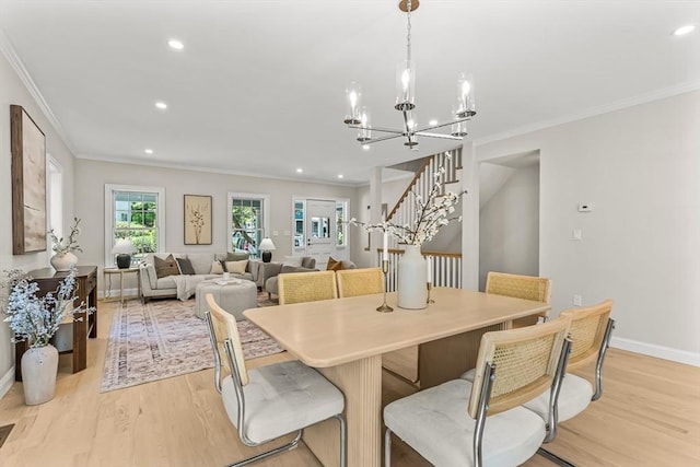 dining area featuring crown molding, an inviting chandelier, light wood finished floors, stairs, and recessed lighting