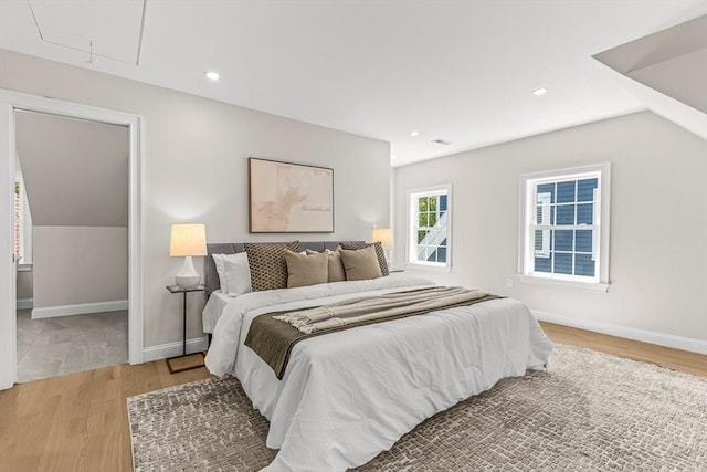 bedroom with recessed lighting, baseboards, attic access, and light wood-type flooring