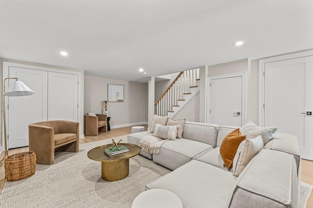 living room with light wood-style floors, recessed lighting, and stairs