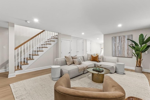 living area with baseboards, stairs, and wood finished floors